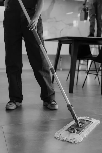 An individual disinfects a workspace using fumigation, wearing full protective gear for safety.